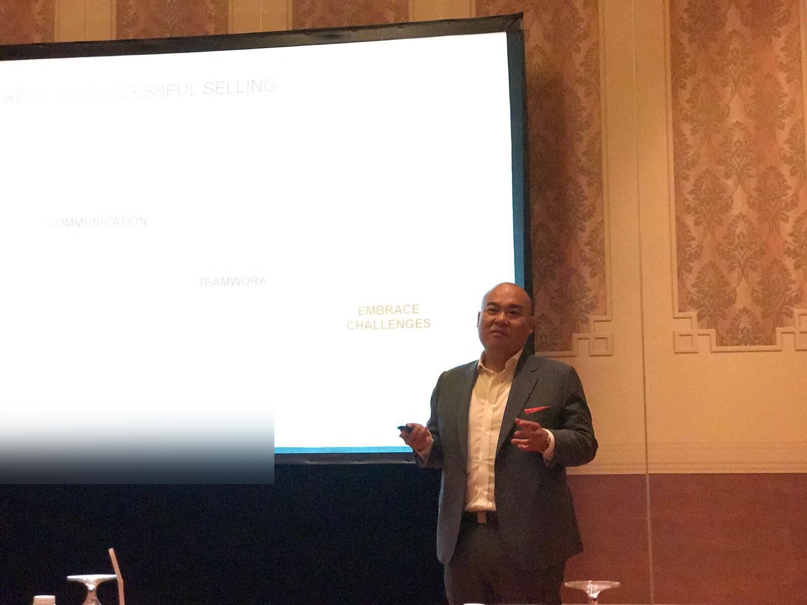 Marcus Lim presenting on stage to a corporate audience